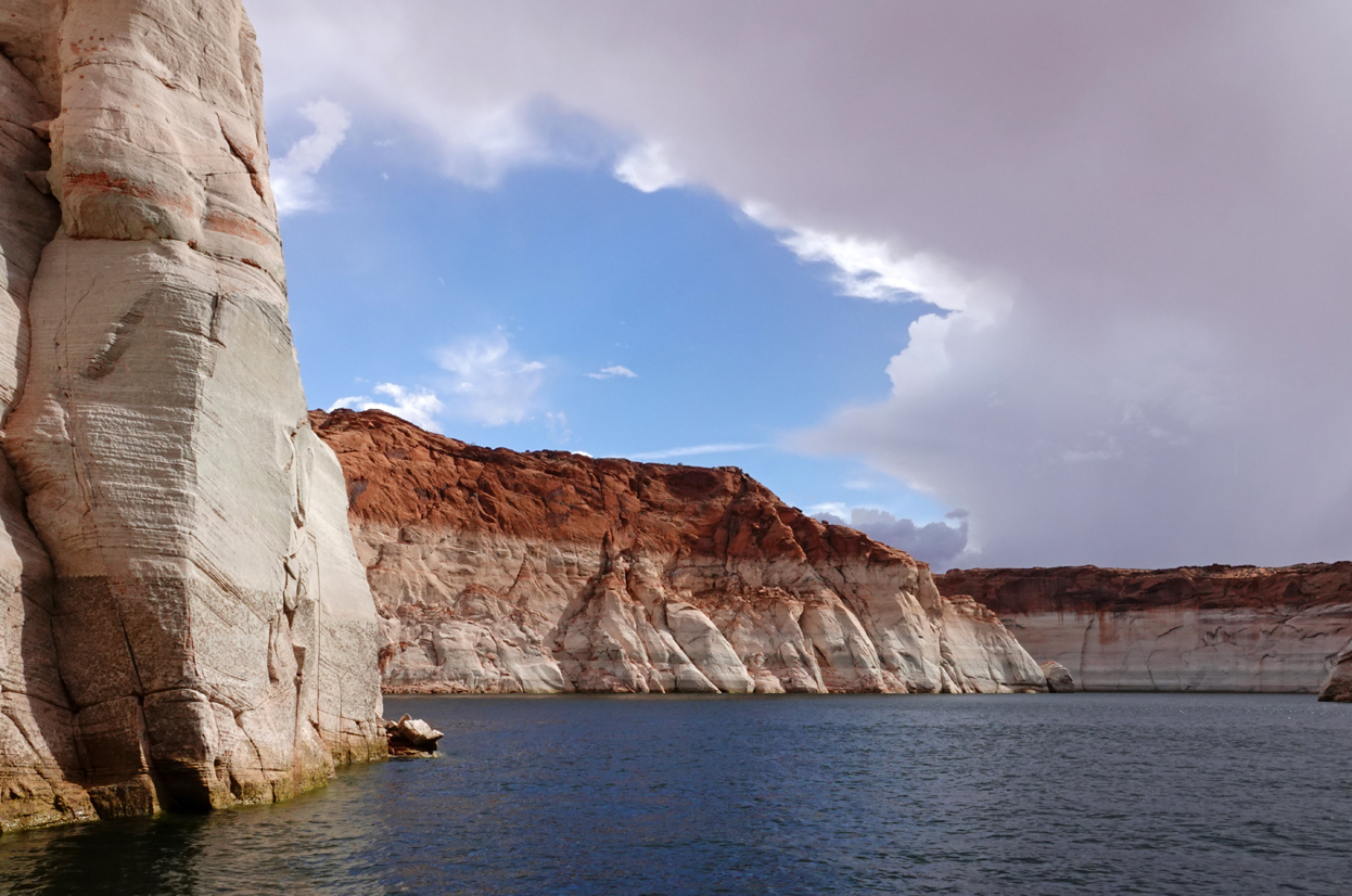 Sandstone cliffs, clouds  -  Navajo Canyon, Lake Powell, Glen Canyon National Recreation Area, Arizona --- Norman’s Note: The boundary between the red and white sandstone shows the Full Pool level of Lake Powell, which was last reached in 1999.  At the time of our cruise, the water level was down 154 feet from Full Pool.