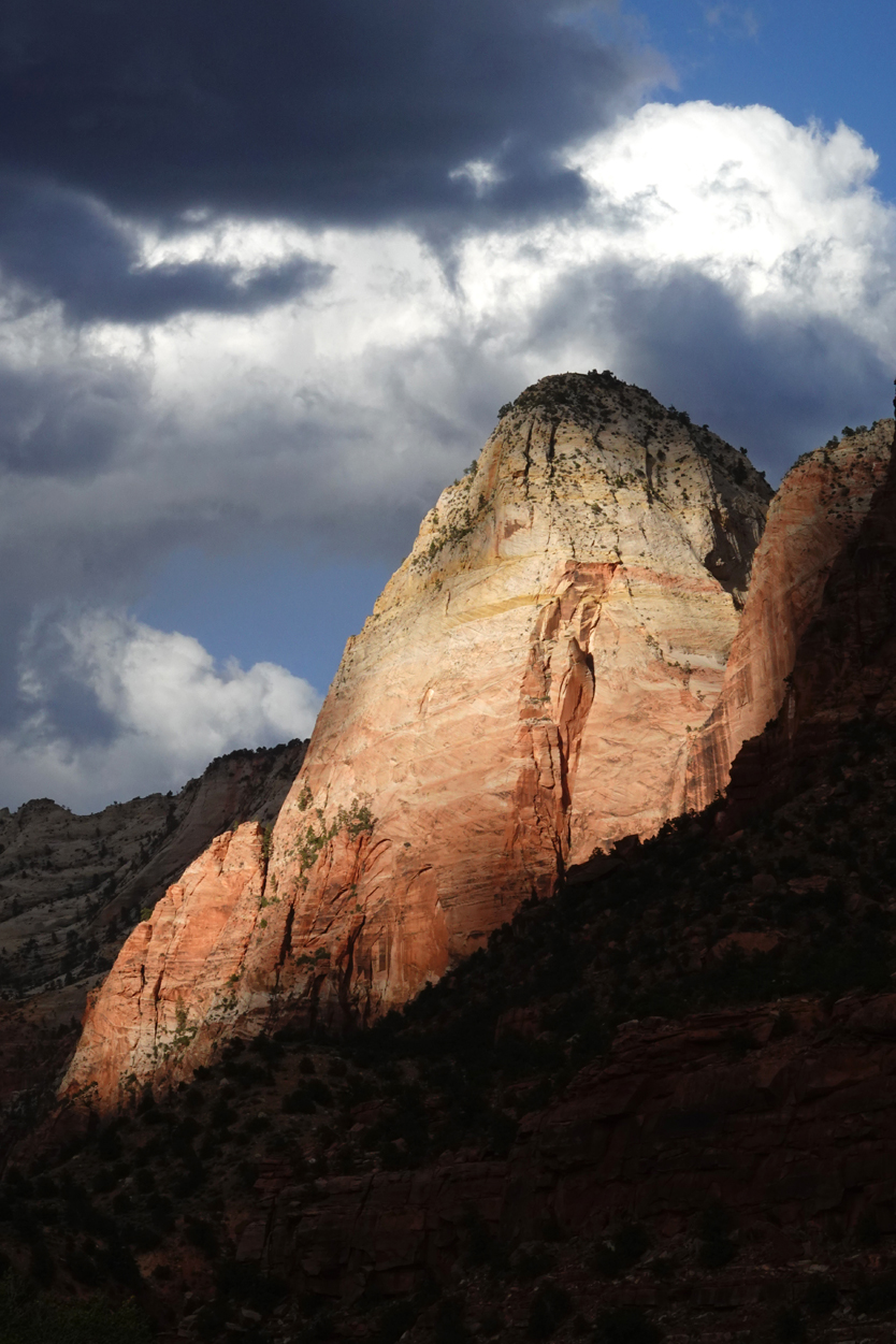 Late-day light on sandstone cliffs, storm clouds  -  from the Museum of Human History, Zion National Park, Utah