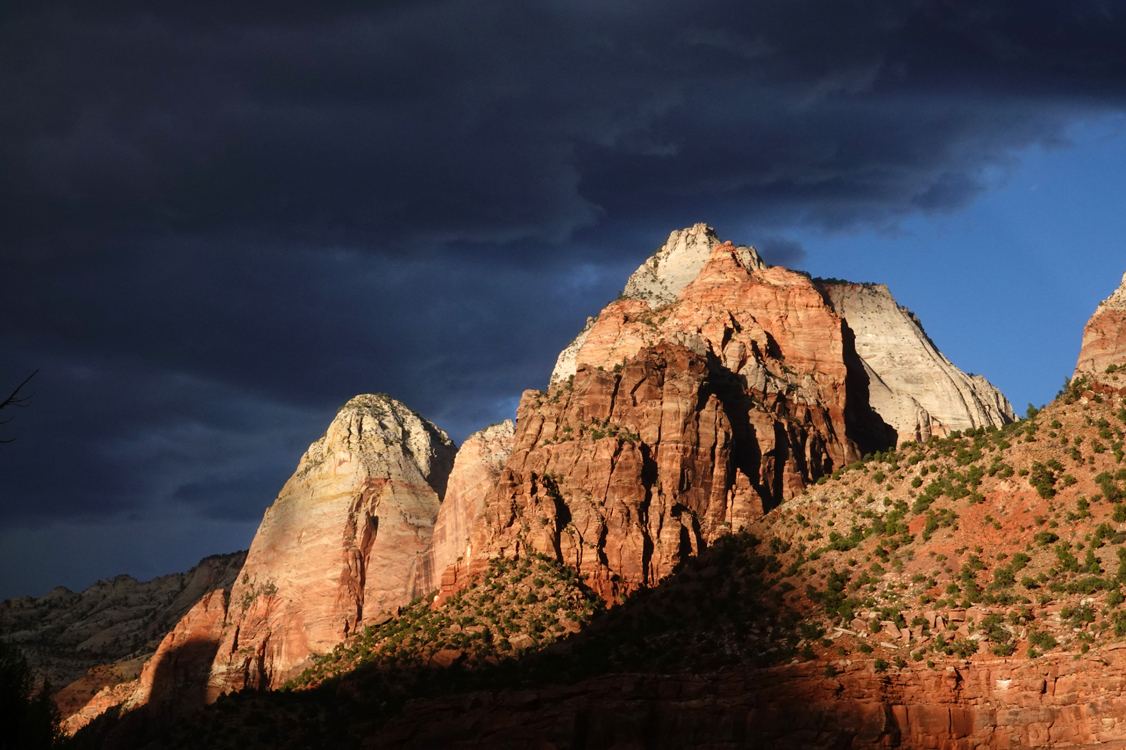 Late-day light on sandstone cliffs, storm clouds  -  from the Museum of Human History, Zion National Park, Utah