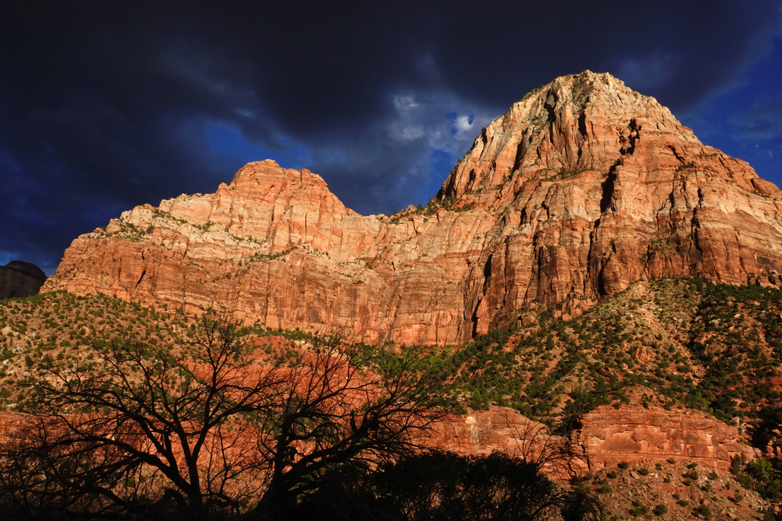 Late-day light on sandstone cliffs, storm clouds  -  from the Museum of Human History, Zion National Park, Utah