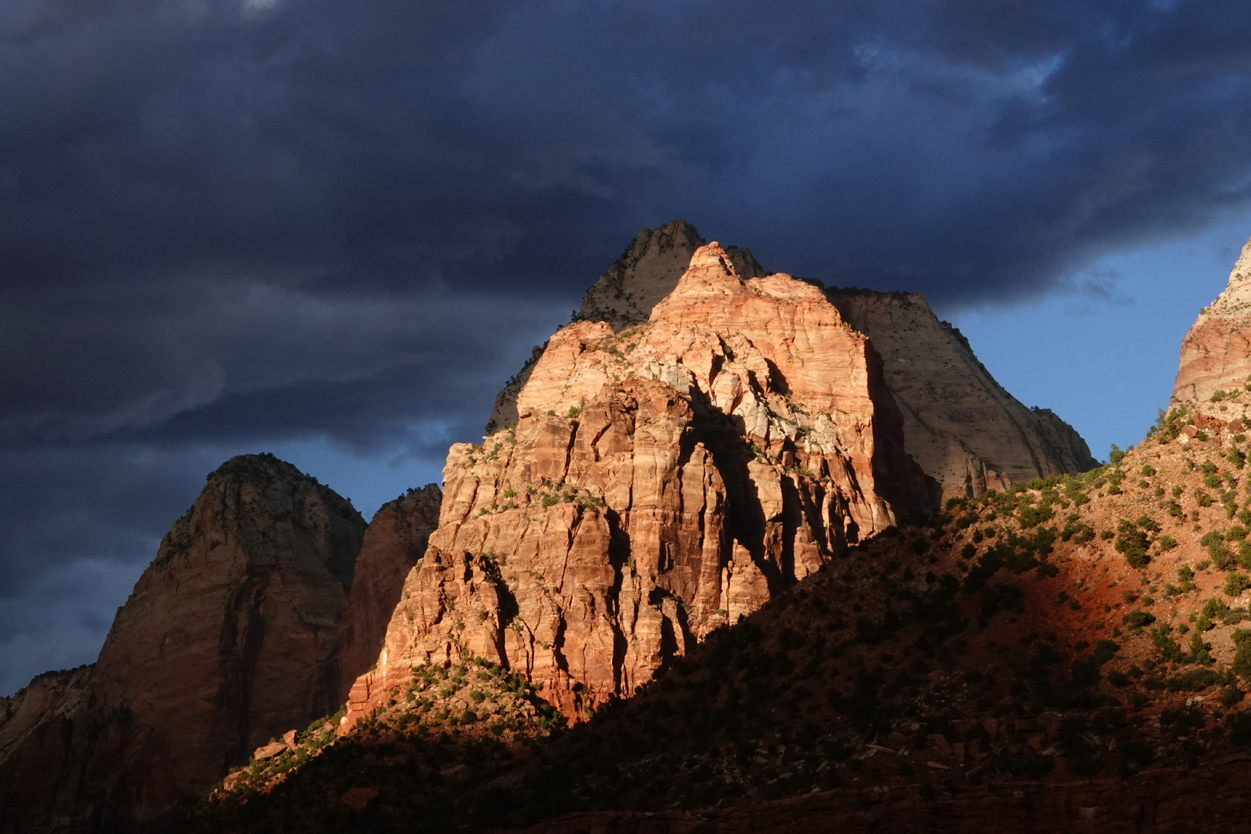 Late-day light on sandstone cliffs, storm clouds  -  from the Museum of Human History, Zion National Park, Utah