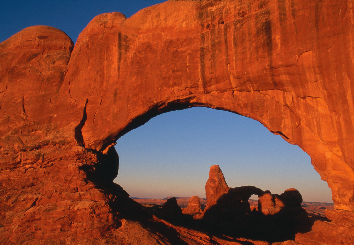 Turret Arch through North Window at sunrise  -  Windows Section, Arches National Park, Utah